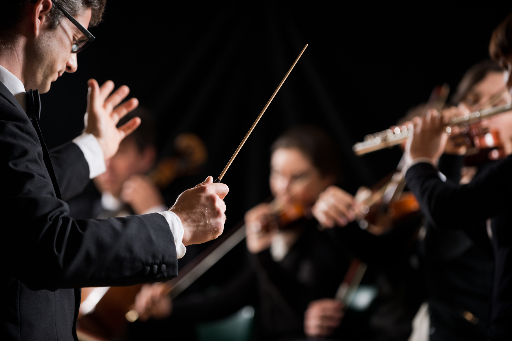 Conductor Directing Symphony Orchestra With Performers